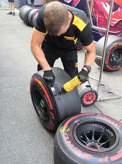 Pirelli technitian scraping the tyres used in the practice session