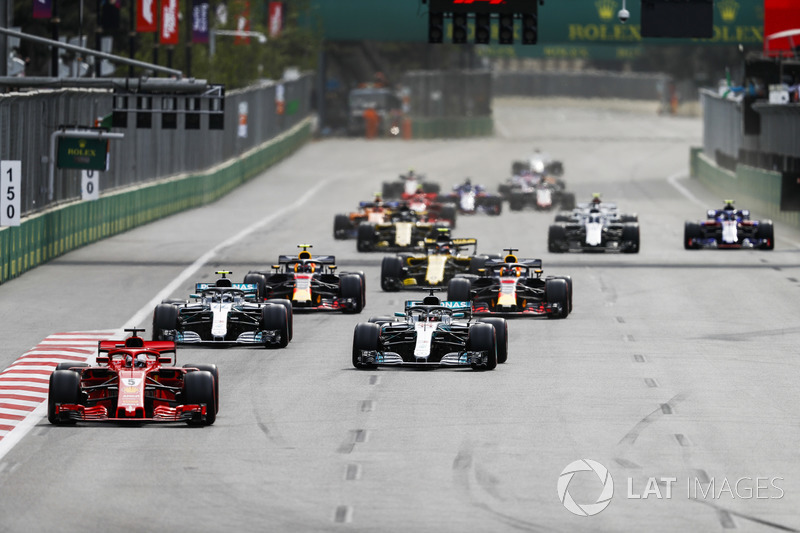 Sebastian Vettel, Ferrari SF71H, leads Lewis Hamilton, Mercedes AMG F1 W09, Valtteri Bottas, Mercedes AMG F1 W09, Daniel Ricciardo, Red Bull Racing RB14 Tag Heuer, Max Verstappen, Red Bull Racing RB14 Tag Heuer, and the rest of the field after a restart
