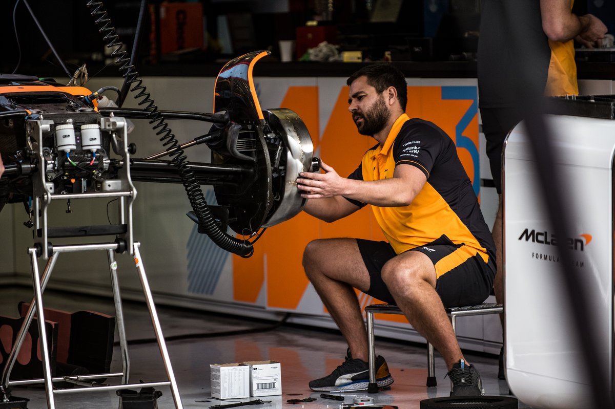 Un mécanicien s'affaire sur les freins avant de la McLaren MCL36