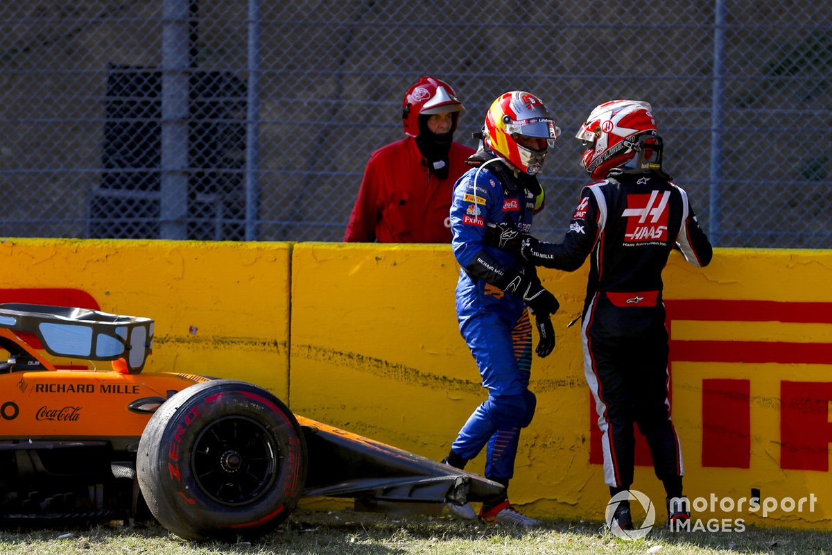 Carlos Sainz Jr., McLaren, and Kevin Magnussen, Haas F1, talk after crashing out of the race