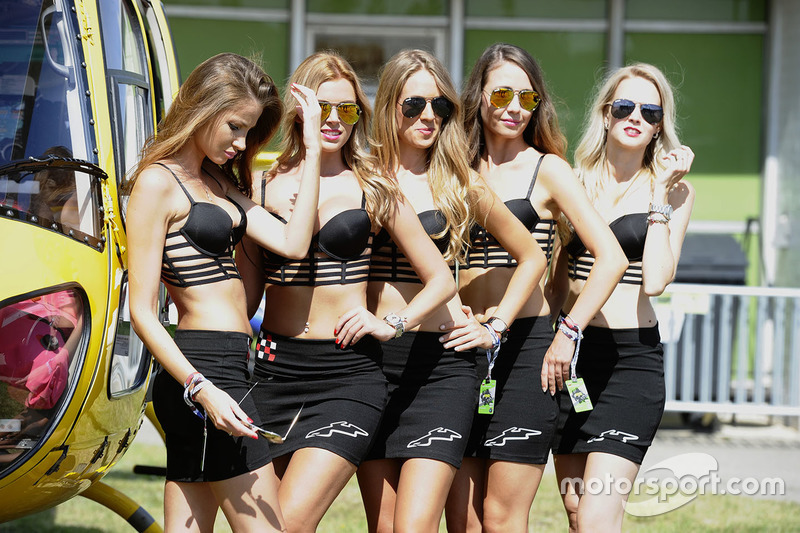 Grid girls in posa con un elicottero