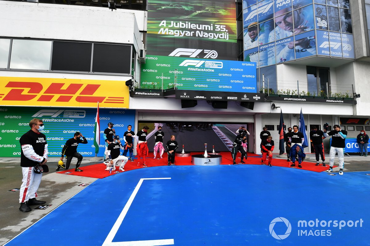 The drivers stand and kneel in support of the End Racism campaign