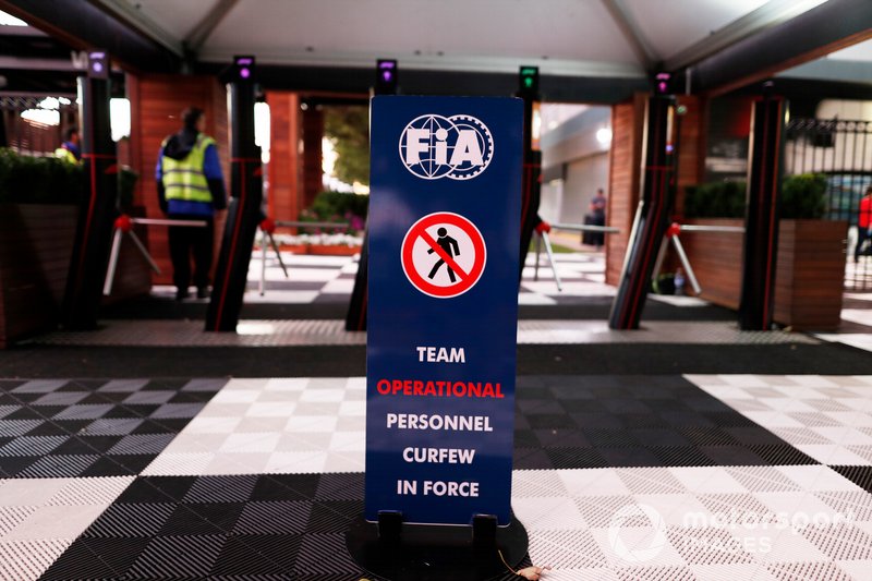 La señal estándar de toque de queda nocturno fuera de las puertas de acceso al paddock.