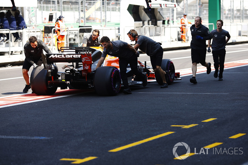 Stoffel Vandoorne, McLaren MCL32, con la ayuda de mecánico que deja fuera de su garaje en el pit lane