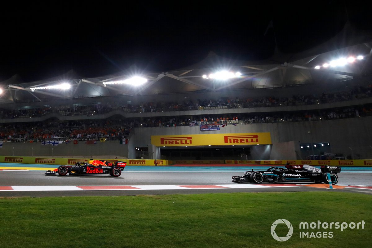 Max Verstappen, Red Bull Racing RB16B, Lewis Hamilton, Mercedes W12, saat bertarung di lap terakhir F1 GP Abu Dhabi, Minggu (12/12/2021) lalu.