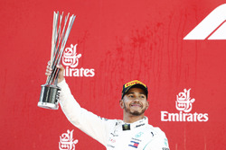 Lewis Hamilton, Mercedes AMG F1, raises his trophy in celebration on the podium