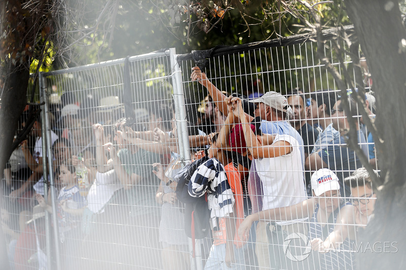 Fans wave to the drivers