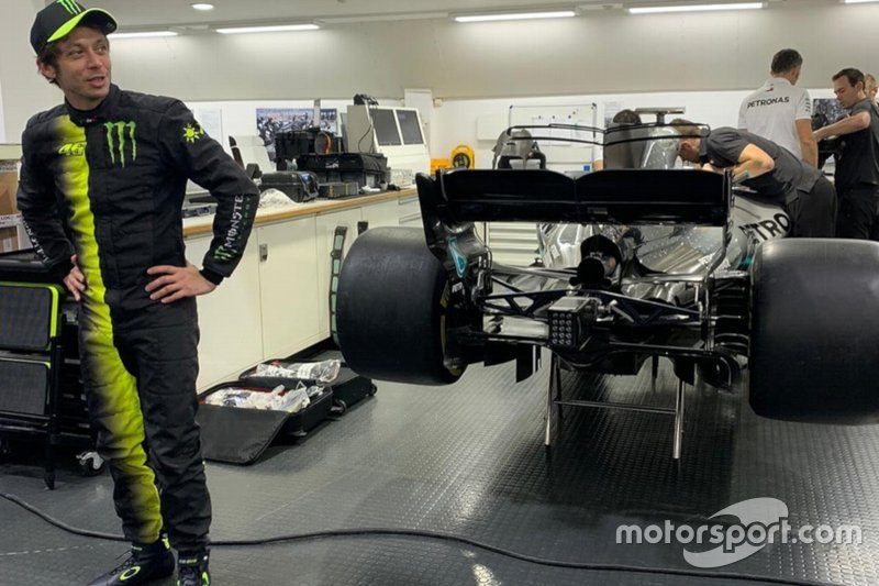 Valentino Rossi con la tuta della Monster di fianco alla Mercedes di Formula 1