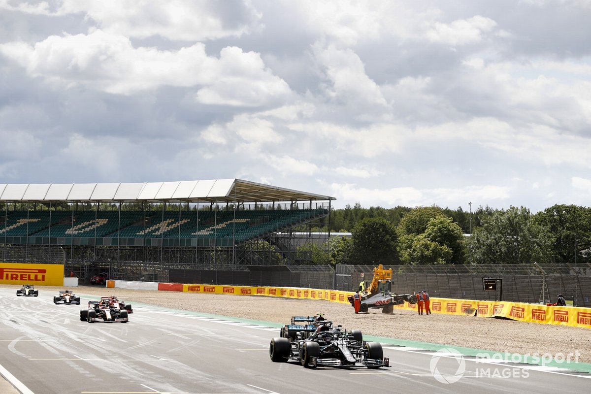 Lewis Hamilton, Mercedes F1 W11, Valtteri Bottas, Mercedes F1 W11, and Max Verstappen, Red Bull Racing RB16, as they pass the crashed car of Kevin Magnussen, Haas VF-20