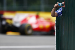 Kimi Raikkonen, Ferrari SF70H, passes a fan taking a picture