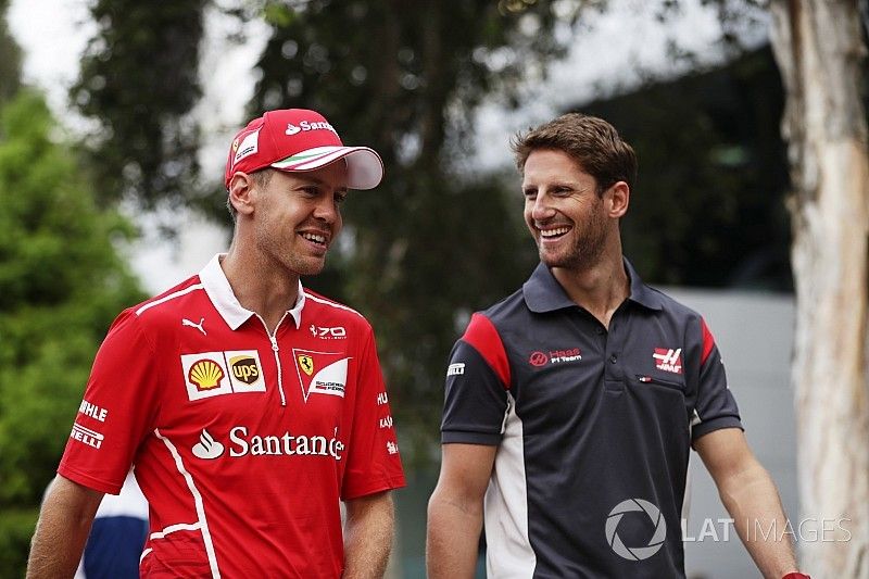 Sebastian Vettel, Ferrari, walks, Romain Grosjean, Haas F1 Team, in the paddock