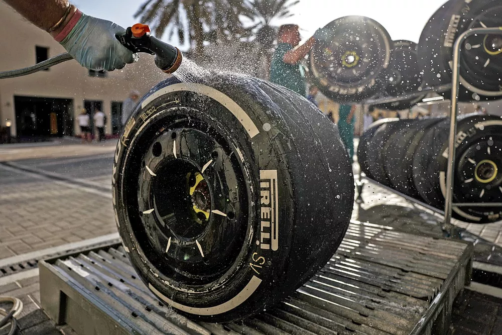 An Aston Martin mechanic washes some tyres