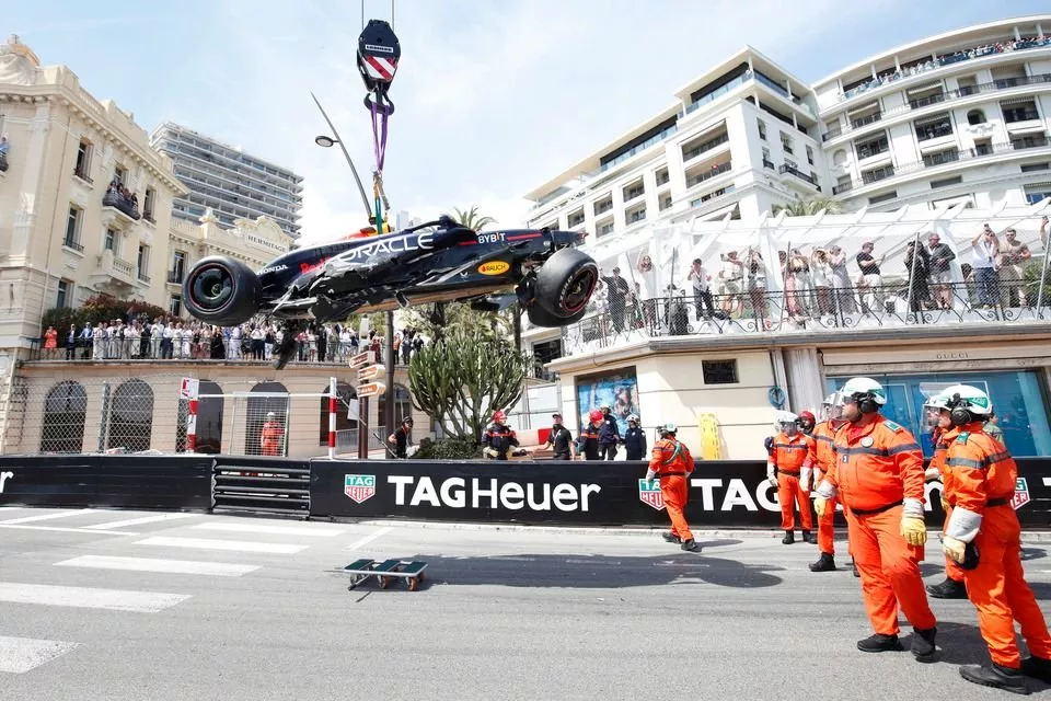 Marshals verwijderen de beschadigde auto van Sergio Perez, Red Bull Racing RB20, na een crash in de openingsronde