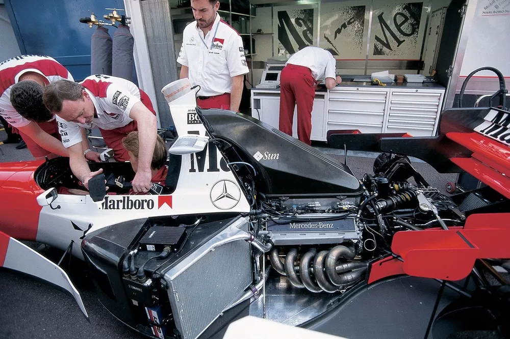 Des m&eacute;caniciens McLaren attachent Mika Hakkinen, dans sa MP4-10 Mercedes