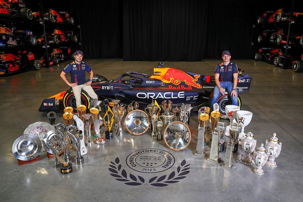 Sergio Pérez y Max Verstappen con los trofeos de 2023 en la fábrica de Red Bull en Milton Keynes