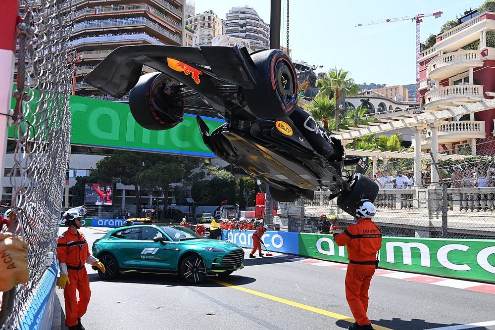 Marshals remove the damaged car of Sergio Perez, Red Bull Racing RB19, from the circuit after a crash in Q1