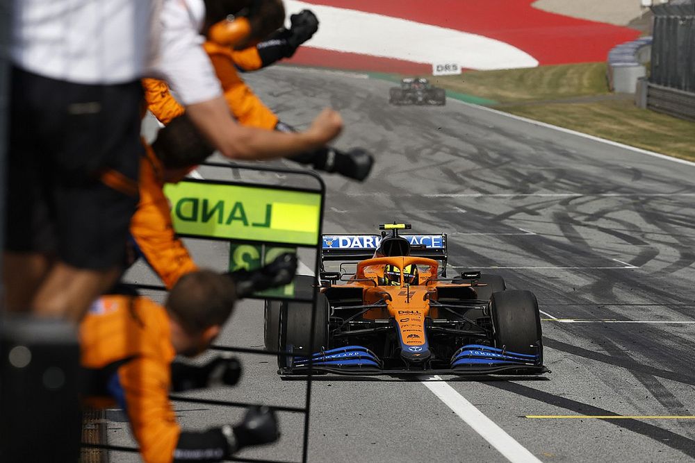Lando Norris, McLaren MCL35M, 3rd position, passes his team as they celebrate on the pit wall

