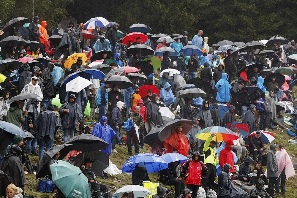 Fans under umbrellas during a red flag period
