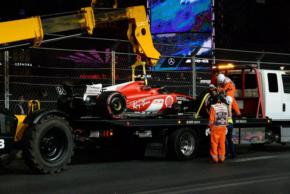 Oficiales de pista cargan el coche dañado de Carlos Sainz, Ferrari SF-23, en una grúa