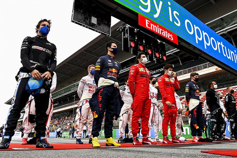 The drivers stand in line for the national anthems on the grid prior to the start