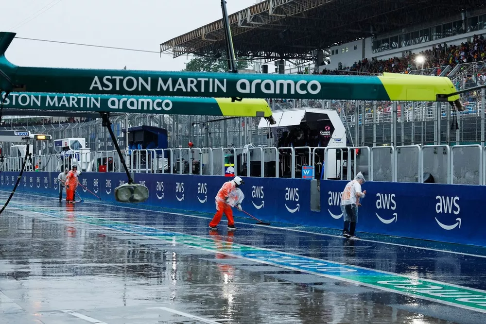 Marshals sweep water from the track