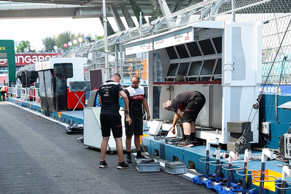 Alfa Romeo mechanics at work next to their pit lane pit perch