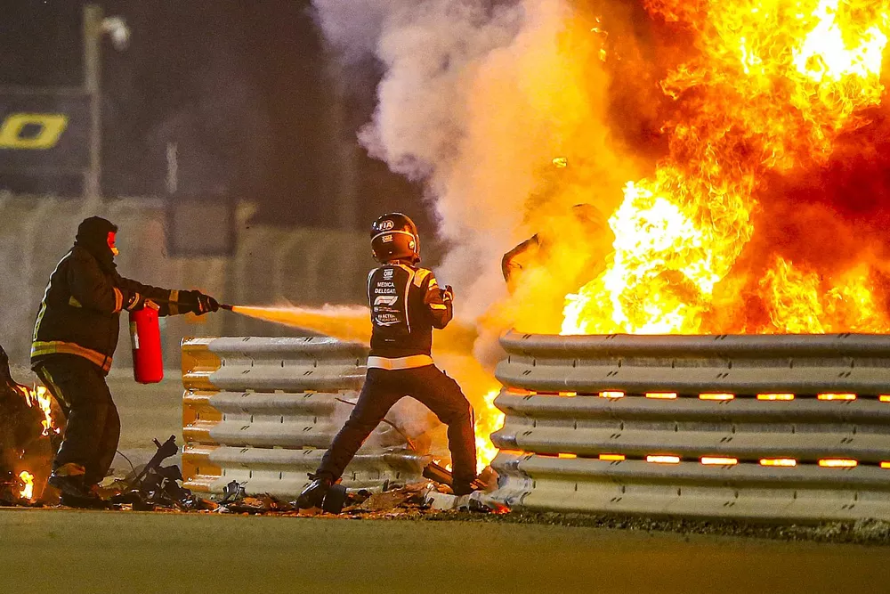Los bomberos se encargan de las llamas y un delegado m&eacute;dico saca a Romain Grosjean, Haas F1 del monoplaza