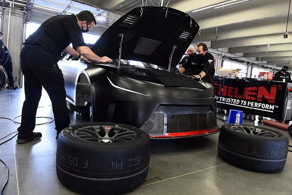 Team members make adjustments to the Nascar Next Gen car