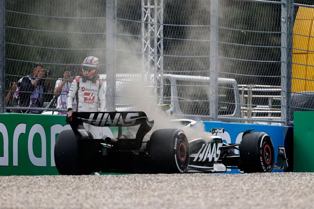 Nico Hulkenberg, Haas VF-23, climbs out of his smoking car and retires from the race