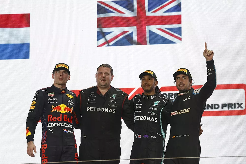Max Verstappen, Red Bull Racing, 2nd position, the Mercedes trophy delegate, Lewis Hamilton, Mercedes, 1st position, and Fernando Alonso, Alpine F1, 3rd position, on the podium