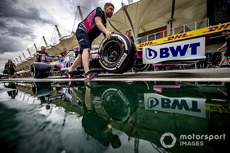 Des m&eacute;caniciens Racing Point poussent la voiture de Sergio Perez dans la pitlane