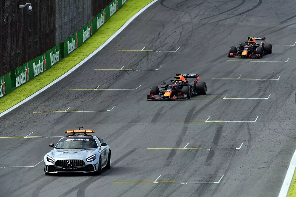 The Safety Car leads Max Verstappen, Red Bull Racing RB15, and Alexander Albon, Red Bull RB15