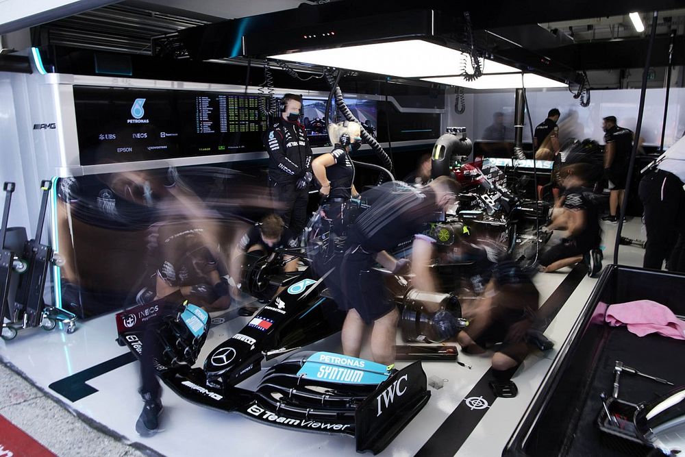 Mechanics work on the car of Lewis Hamilton, Mercedes W12, in the garage