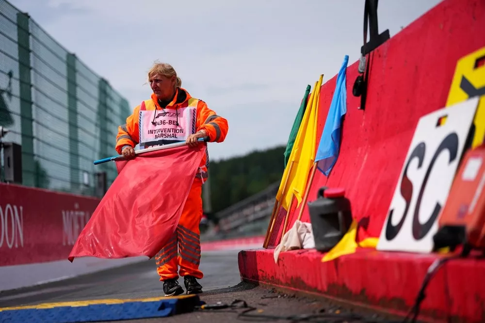 Un oficial de pista prepara la bandera roja