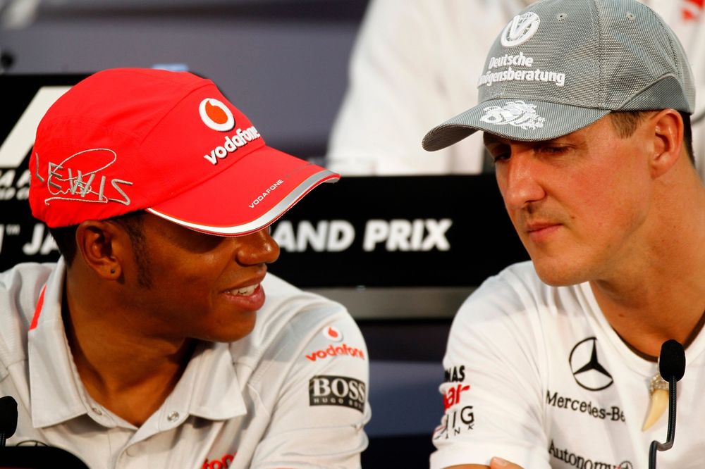 Lewis Hamilton, da McLaren, e Michael Schumacher, da Mercedes, conversam entre si durante a coletiva de imprensa de quinta-feira