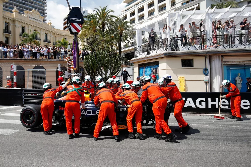 Comisarios de pista retirando el coche de Sergio Perez, Red Bull Racing RB20