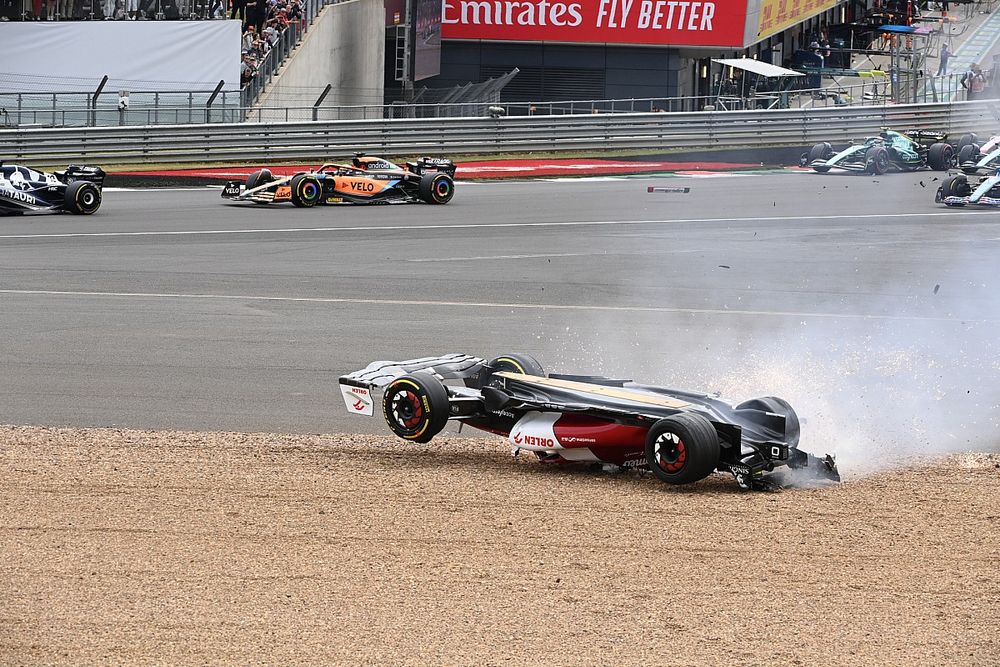 Zhou Guanyu, Alfa Romeo C42, slides across the gravel during a crash at the start