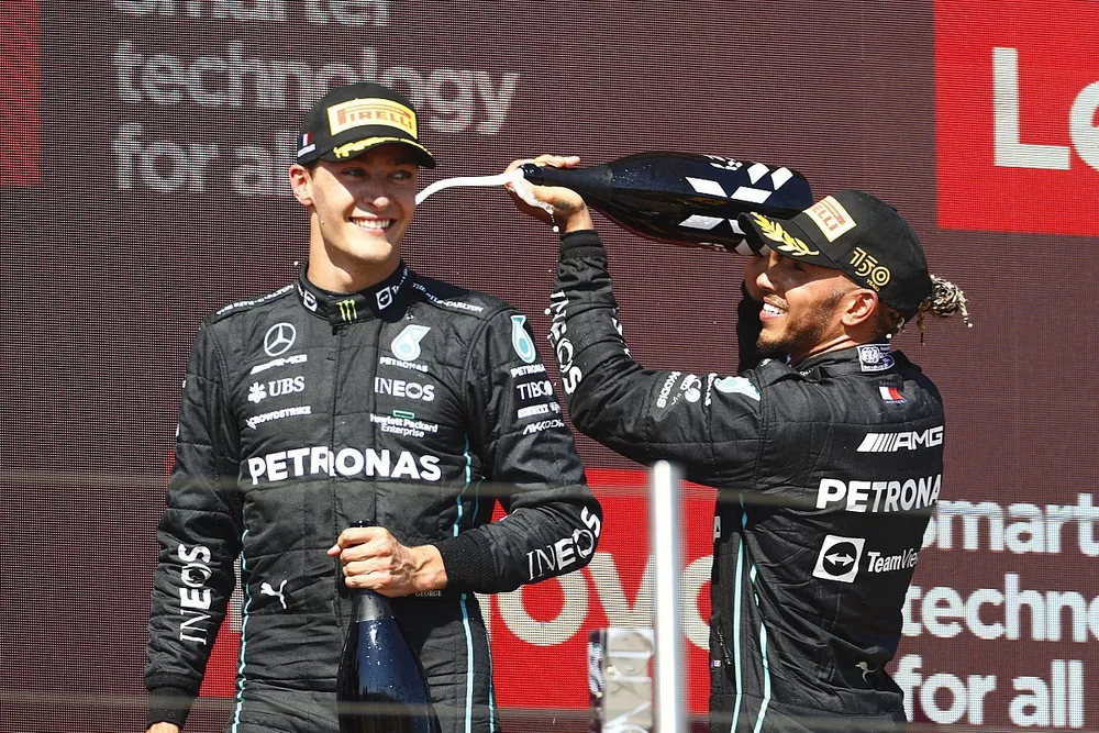 Lewis Hamilton, Mercedes-AMG, 2nd position, sprays George Russell, Mercedes-AMG, 3rd position, with Champagne on the podium