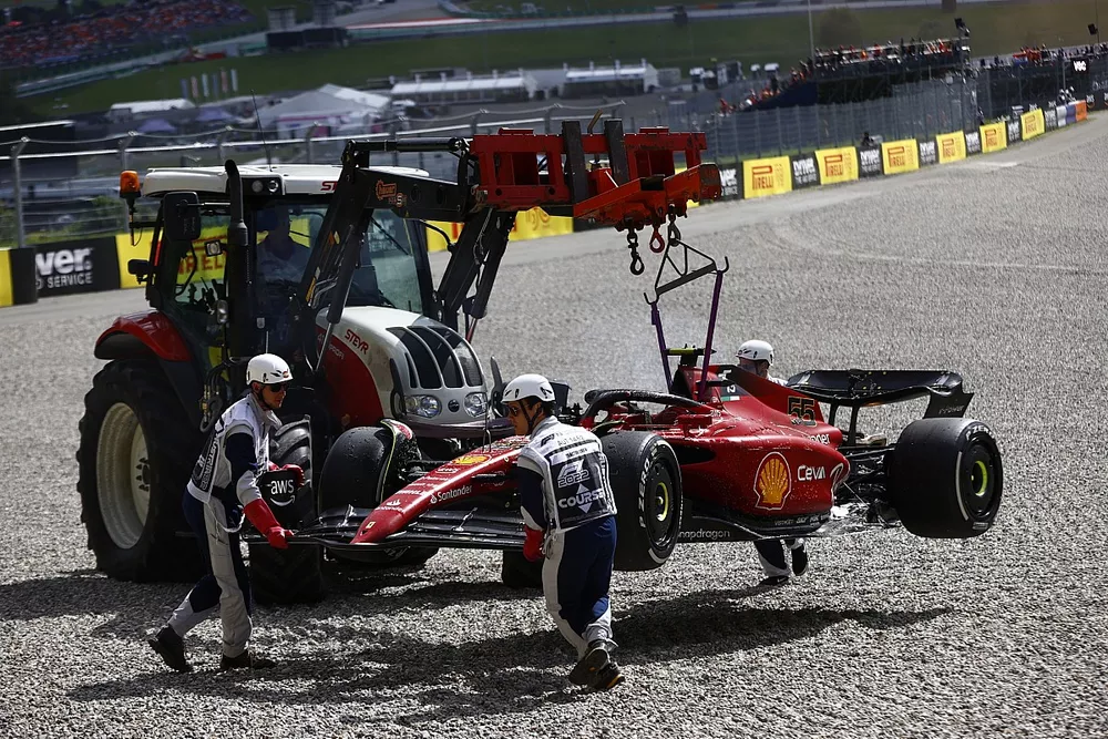 Marshals remove the fire damaged car of Carlos Sainz, Ferrari F1-75