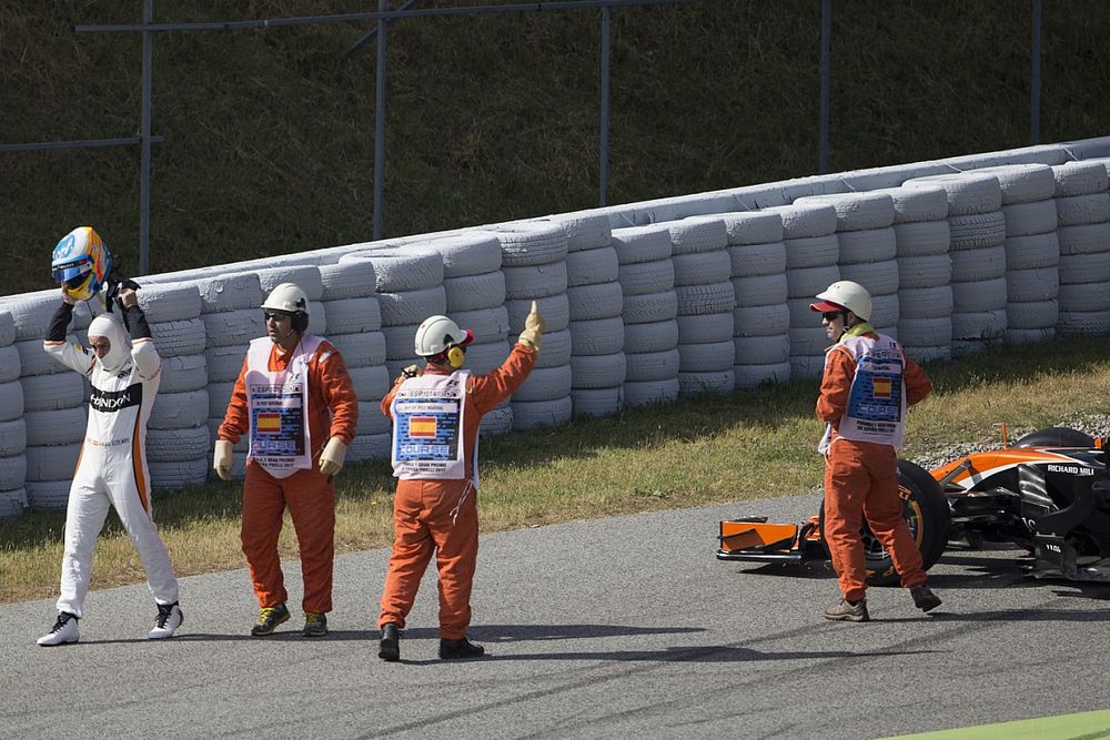 Oficiales de pista asisten a Fernando Alonso, McLaren MCL32 al tener con problemas de motor