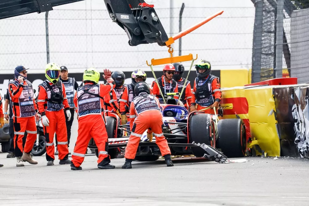 Marshals remove the damaged car of Yuki Tsunoda, RB F1 Team VCARB 01, from a barrier after a crash at the end of Q2