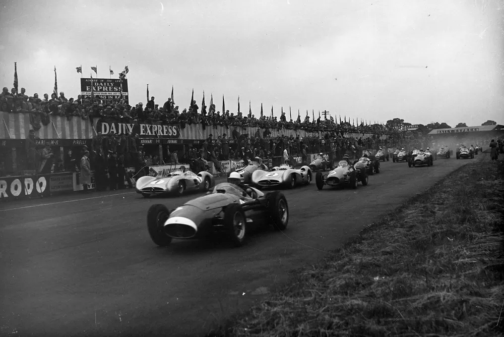 Stirling Moss, Maserati 250F, leads Juan Manuel Fangio, Mercedes W196 (#1), Jean Behra, Gordini T16 (#17), Karl Kling, Mercedes W196 (#2), and Mike Hawthorn, Ferrari 625 (#11), at the start.