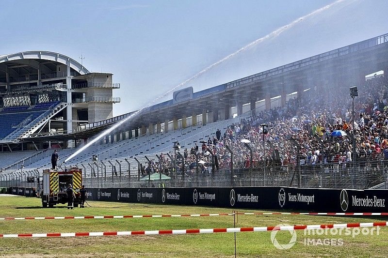 Fans rociados con agua de un camión de bomberos para sofocar el calor