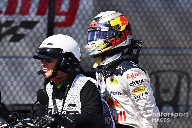 Daniel Ricciardo, Red Bull Racing on the back of a motorbike after retiring 