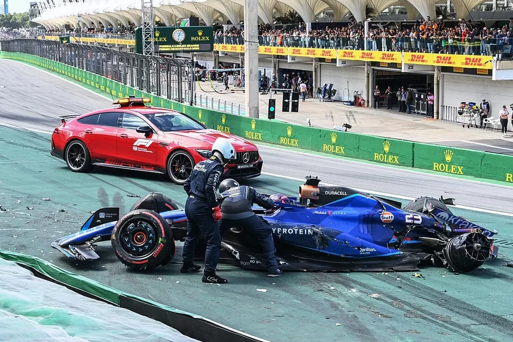 Delegados médicos de la FIA asisten a Alex Albon, Williams FW45, tras un choque en la salida con Kevin Magnussen, Haas VF-23