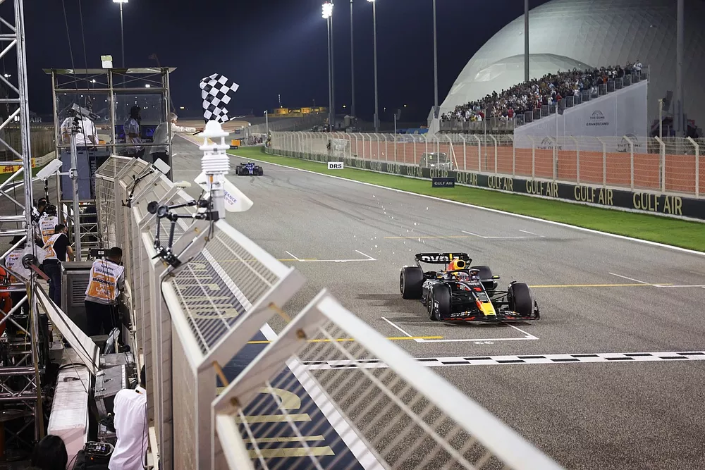 Max Verstappen, Red Bull Racing RB19, 1e positie, neemt de geblokte vlag.