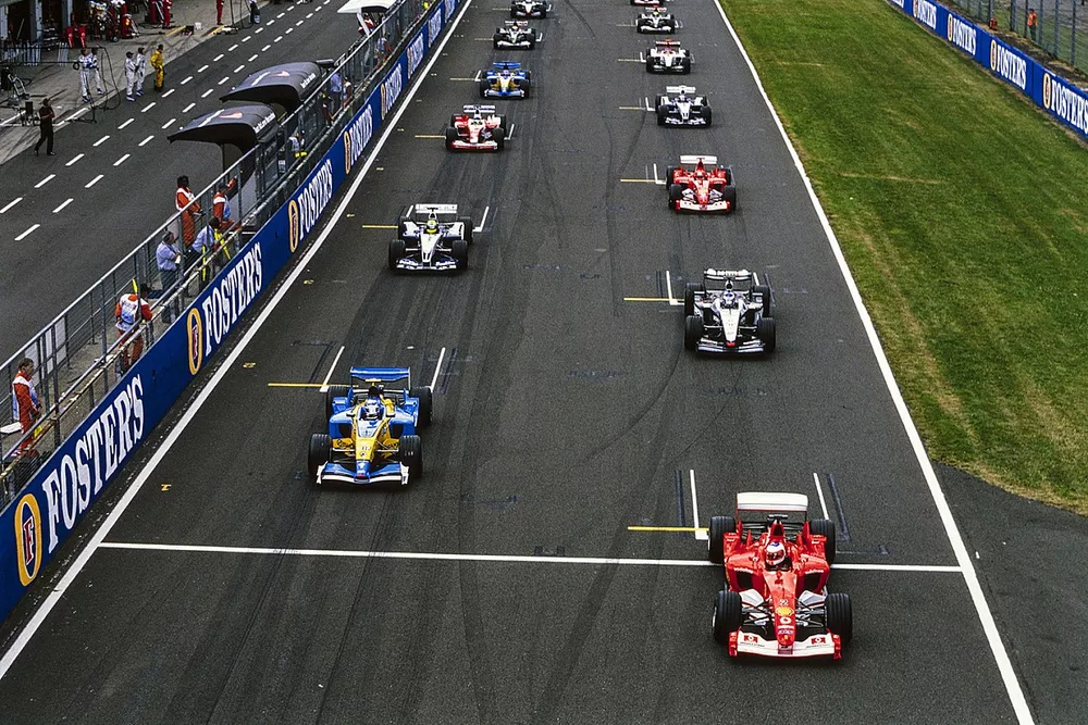 Rubens Barrichello, Ferrari F2003-GA, battles with Jarno Trulli, Renault R23B, at the start