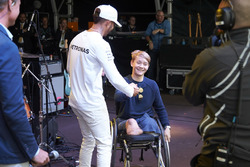 Lewis Hamilton, Mercedes AMG F1 en el escenario con con el piloto de British Formula 4 Billy Monger