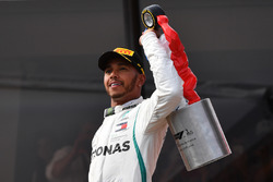 Le vainqueur Lewis Hamilton, Mercedes-AMG F1, sur le podium avec son trophée et le champagne