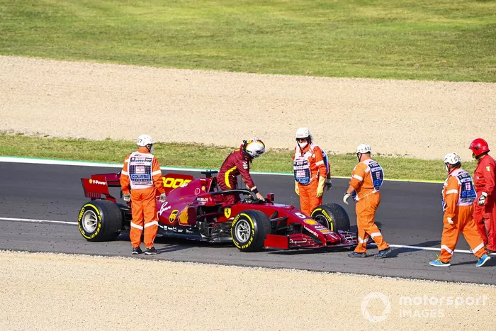 Los oficiales asisten mientras Sebastian Vettel, Ferrari SF1000 se detiene en la pista